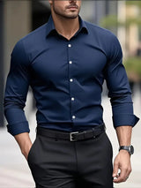 Uomo in camicia blu elegante e pantaloni neri, cammina in città. Moda maschile, abbigliamento formale, stile urbano, orologio da polso.