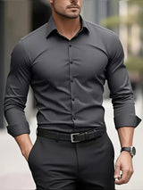 Uomo in camicia grigia elegante e pantaloni neri, cammina in città. Moda maschile, abbigliamento formale, stile urbano.