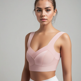 Giovane donna in top sportivo rosa, design moderno, posa su sfondo neutro. Abbigliamento fitness femminile, moda sportiva, comfort e stile.