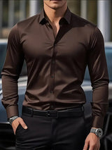 Camicia elegante uomo marrone scuro, abbinata a pantaloni neri e orologio da polso, moda maschile, abbigliamento formale, stile sofisticato.