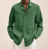 Camicia verde in lino da uomo, maniche lunghe, abbinata a pantaloni bianchi. Stile casual ed elegante, ideale per moda estiva maschile.