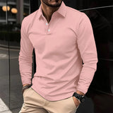 Uomo con camicia polo rosa, pantaloni beige, orologio nero, in piedi all'aperto. Moda maschile elegante, abbigliamento casual urbano.