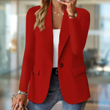 Donna in giacca rossa elegante, indossa jeans e top bianco, in ufficio moderno. Moda femminile, abbigliamento business casual, stile professionale.
