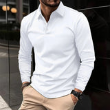 Uomo con camicia bianca a maniche lunghe, pantaloni beige, orologio nero, sfondo urbano. Moda maschile elegante, stile casual chic.