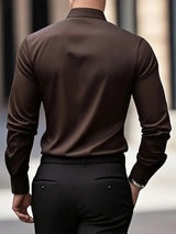 Camicia uomo marrone elegante, vista posteriore, abbinata a pantaloni neri. Moda maschile, abbigliamento formale, stile sofisticato.
