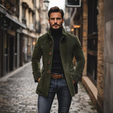 Uomo elegante in cappotto verde su strada acciottolata, moda autunnale, stile urbano, abbigliamento maschile, look casual chic, città europea.