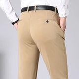 Pantaloni eleganti beige da uomo, tasche posteriori con bottoni, camicia bianca, cintura nera. Moda maschile, abbigliamento formale.