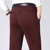 Pantaloni eleganti uomo marroni, tasche posteriori, cintura nera, camicia bianca. Moda maschile, abbigliamento formale, stile classico.