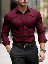 Uomo in camicia bordeaux elegante, pantaloni neri, orologio al polso, cammina in città. Moda maschile, abbigliamento formale, stile urbano.