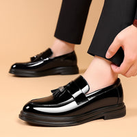 Scarpe eleganti uomo in pelle nera lucida con nappine, indossate con pantaloni neri. Scarpe formali, moda maschile, calzature di lusso.