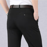 Pantaloni eleganti neri da uomo, vestibilità slim, con cintura marrone e camicia bianca. Stile formale, moda maschile, abbigliamento da ufficio.